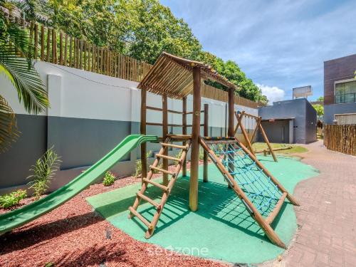 a playground with a slide and a swing set at Condomínio no litoral em Imbassaí - SOV in Imbassai