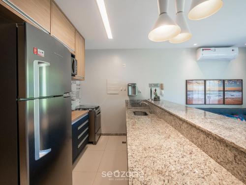 a kitchen with a stainless steel refrigerator and counters at Condomínio no litoral em Imbassaí - SOV in Imbassai