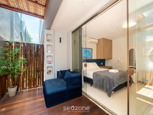 a bedroom with a bed and a glass wall at Condomínio no litoral em Imbassaí - SOV in Imbassai