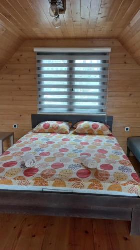 a large bed in a room with a window at Brvnare Libero TARA in Sekulić 