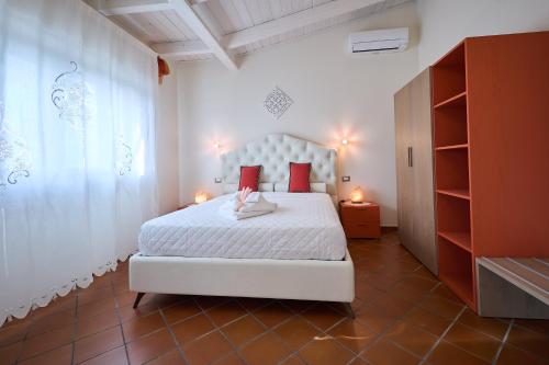 a bedroom with a white bed with red pillows at B&B Luci della Collina Boutique Relax in Tortoreto Lido