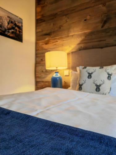 a bedroom with a bed with a lamp on a table at Pension Kleiner König in Struppen-Siedlung