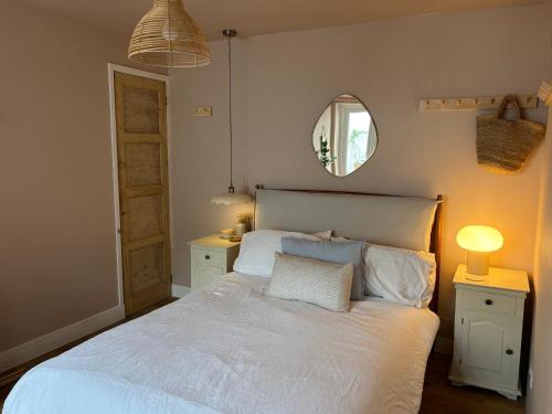 a bedroom with a white bed and a mirror at Cosy, convenient flat in Falmouth in Falmouth