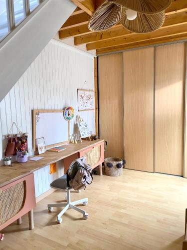 un bureau mansardé avec un bureau et une chaise dans l'établissement Maison Cozy, à La Rochelle