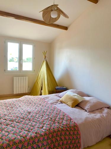 une chambre avec un lit et un ventilateur de plafond dans l'établissement Maison Cozy, à La Rochelle