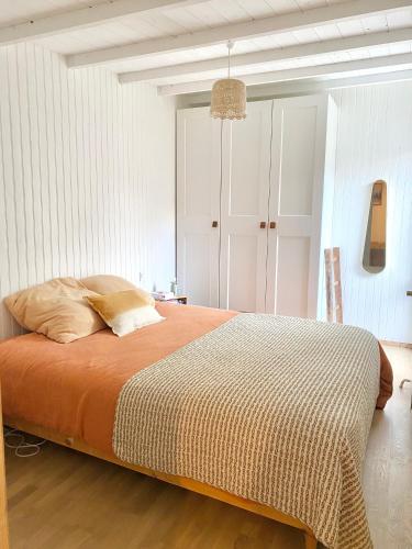une chambre avec un grand lit avec une couverture orange dans l'établissement Maison Cozy, à La Rochelle