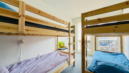 deux lits superposés dans une chambre avec fenêtre dans l'établissement Le Lion d'or - Parking - Netflix - Wifi - Nerf, à Bussy-Saint-Georges