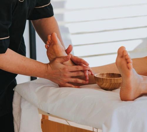 a masseur massaging a patients feet on a bed at Villa Margherita in Marsala