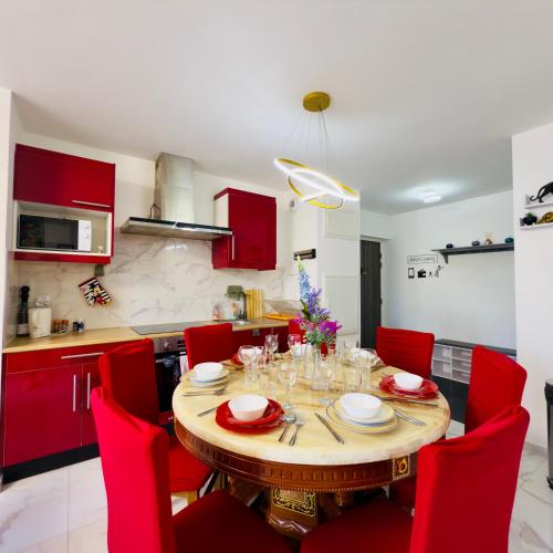 une cuisine avec une table en bois et des chaises rouges dans l'établissement Le Lion d'or - Parking - Netflix - Wifi - Nerf, à Bussy-Saint-Georges