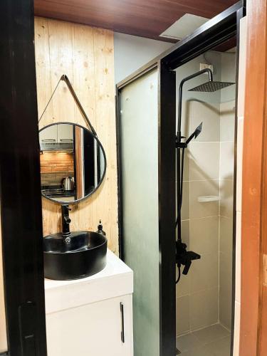 バギオにあるCozy Pine Suitesの洗面台とシャワー付きのバスルーム