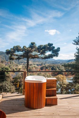 a large wooden barrel sitting on a deck with a view at Vila dos Cedros in Rio dos Cedros