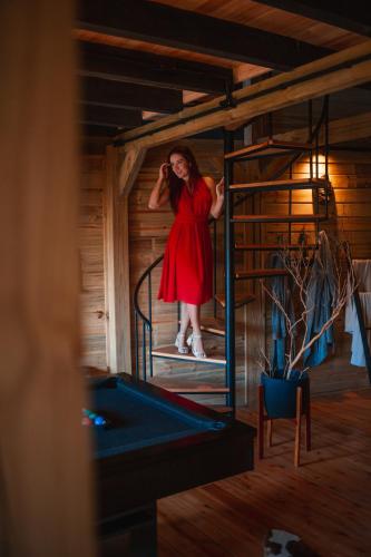 a woman in a red dress standing in a room at Vila dos Cedros in Rio dos Cedros