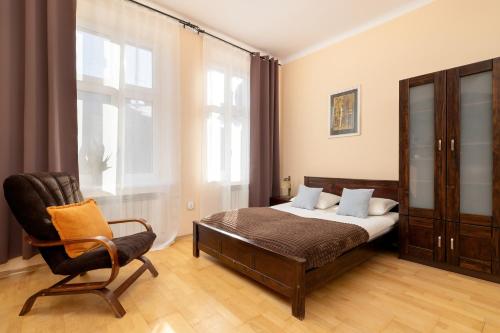 a bedroom with a bed and a chair at Caffe latte apartment in Kraków