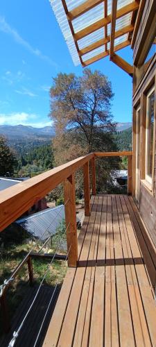 a wooden deck on the side of a house at Cabaña las Frutillas in San Martín de los Andes