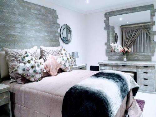 a bedroom with a large bed and a mirror at Ambience on N2 Boutique Hotel in Kokstad