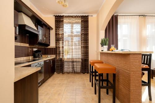 a kitchen with a bar with stools in it at Caffe latte apartment in Kraków