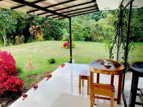 a patio with a table and chairs and a view of a field at Quinta El Dorado - private villa near Mindo in Mindo