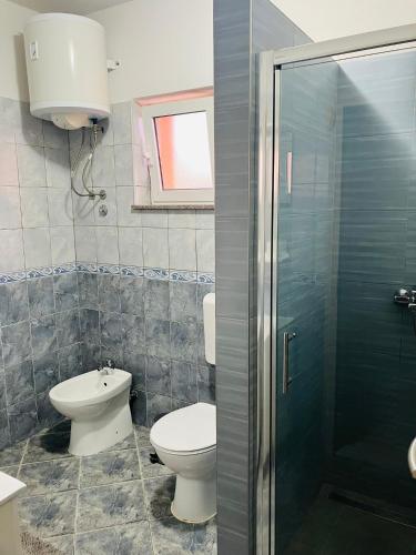 a bathroom with a toilet and a sink and a shower at Apartments & Rooms Seaside in Kaštela