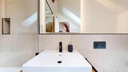 a bathroom with a white sink and a mirror at Apt 11 No 8A BoardingHouse Lüneburg in Lüneburg