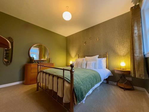 a bedroom with a large bed and a mirror at Cochrane House in Stirling