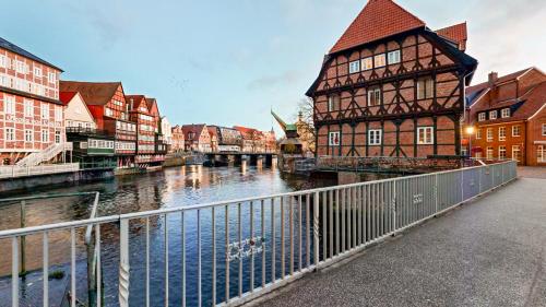 a city with buildings and a river and a bridge at Apt 11 No 8A BoardingHouse Lüneburg in Lüneburg