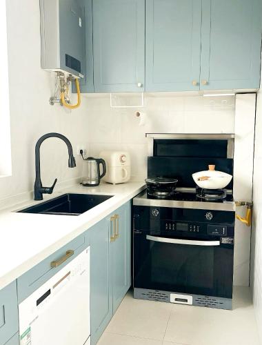 a kitchen with a black stove and a sink at Flaneur Shanghai Hongqiao B&B Near National Exhibition and Convention Center in Shanghai