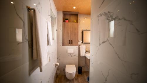 a white bathroom with a toilet and a sink at SM Exclusive Apartments in Visoko