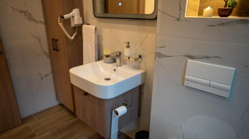 a bathroom with a white sink and a mirror at SM Exclusive Apartments in Visoko