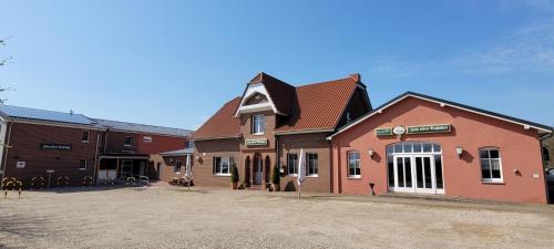 a red building with a sign on top of it at Zum alten Bahnhof in Blunk