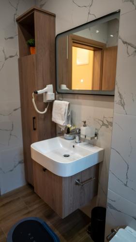 a bathroom with a sink and a mirror at SM Exclusive Apartments in Visoko