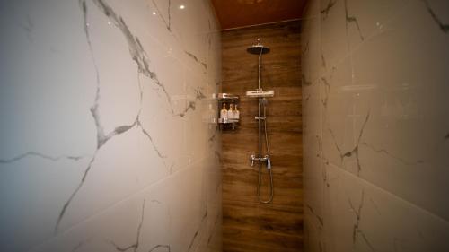 a shower stall in a bathroom with marble walls at SM Exclusive Apartments in Visoko
