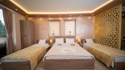 a bedroom with two beds and two windows at SM Exclusive Apartments in Visoko