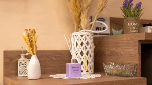 a shelf with vases and a lavender bottle on it at SM Exclusive Apartments in Visoko