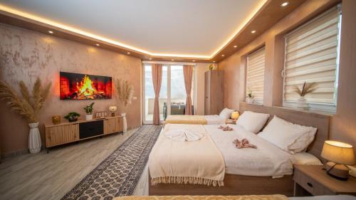 a bedroom with two beds and a fire painting on the wall at SM Exclusive Apartments in Visoko