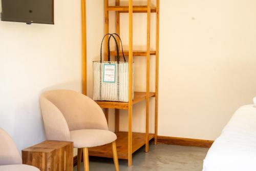 a room with a shelf and two chairs and a table at Equinoccio Hotel in Santa Ana