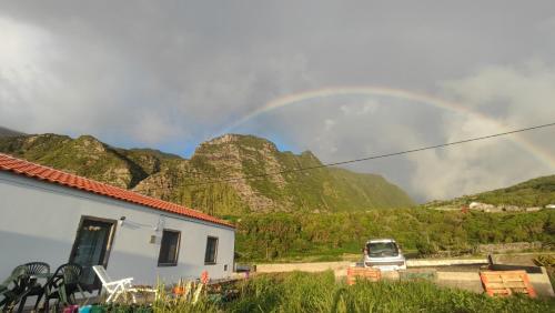 a rainbow over a mountain with a car and a house at Casa do Branco in Faja Grande