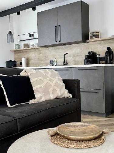 a living room with a black couch and a kitchen at Wyzenborne in Sontra
