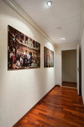 a room with paintings on the walls of a museum at ARCTIC HOMES - Villa Borealis in Tromsø