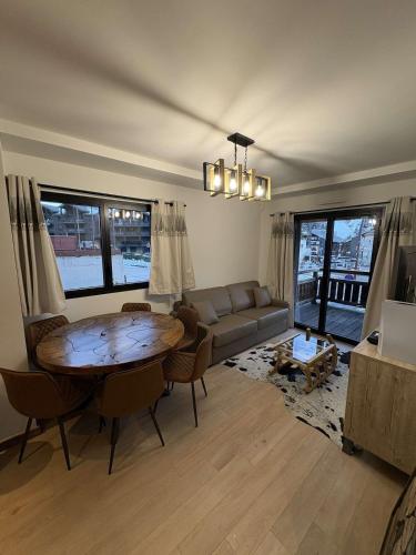 un salon avec une table et un canapé dans l'établissement Apartment Le Monde des Neiges, à Saint-Étienne-de-Tinée
