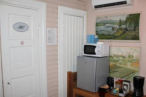 a kitchen with a microwave on top of a refrigerator at Paksuniemen Majatalo in Rääkkylä