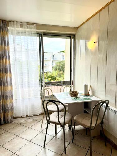 une salle à manger avec une table et des chaises et une fenêtre dans l'établissement La Mouette - Plein Centre Ville, à La Grande Motte