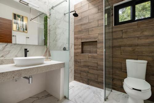 a bathroom with a toilet and a sink and a shower at ¡Increible! Villa Luz de Luna in Akumal