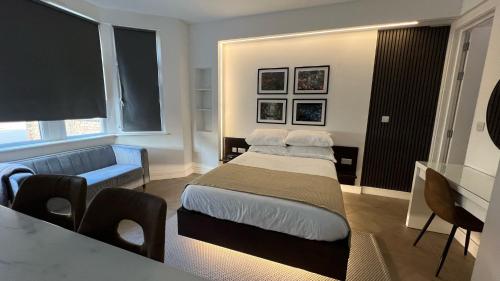 a bedroom with a bed and a couch and a table at Luxurious London Studios in Harrow