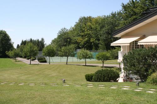 a large yard next to a house with trees at Chalet La Forestière in Saint-Paul-en-Chablais