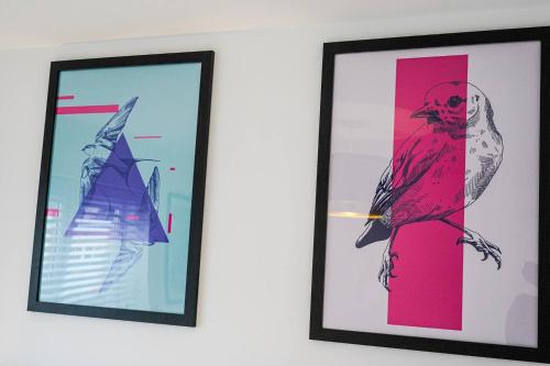 two framed pictures of a bird on a wall at Harvest Way House Shortlets in Witney