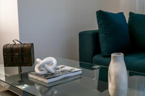 a glass coffee table with two books and a vase at Malibu Villa in Kremasti
