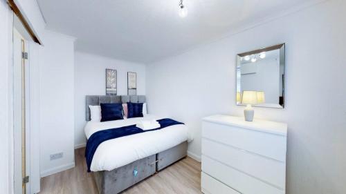 Un dormitorio blanco con una cama y un espejo. en Ranworth-house - Holiday Home In Bedford, Sleeps 5, en Bedford