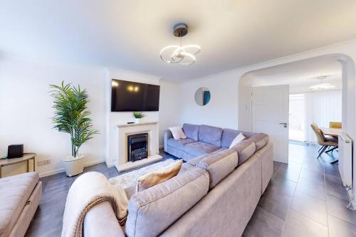 a living room with a couch and a fireplace at Ranworth-House - Perfect for professionals in Bedford