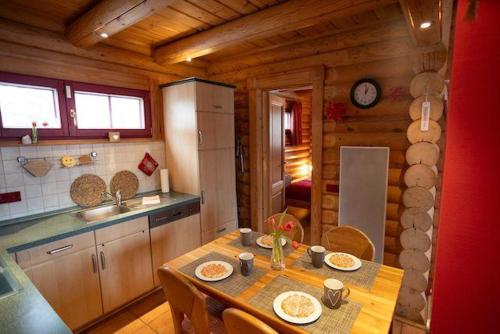 a kitchen with a table in a wooden cabin at HyggeZeit-im-Holzblockhaus-in-Wernigerode in Wernigerode