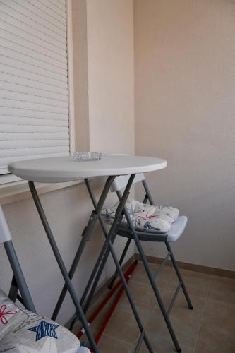 a table and a chair sitting next to a window at Apartman S&V 1 Wellness & Spa Juba in Lukavica